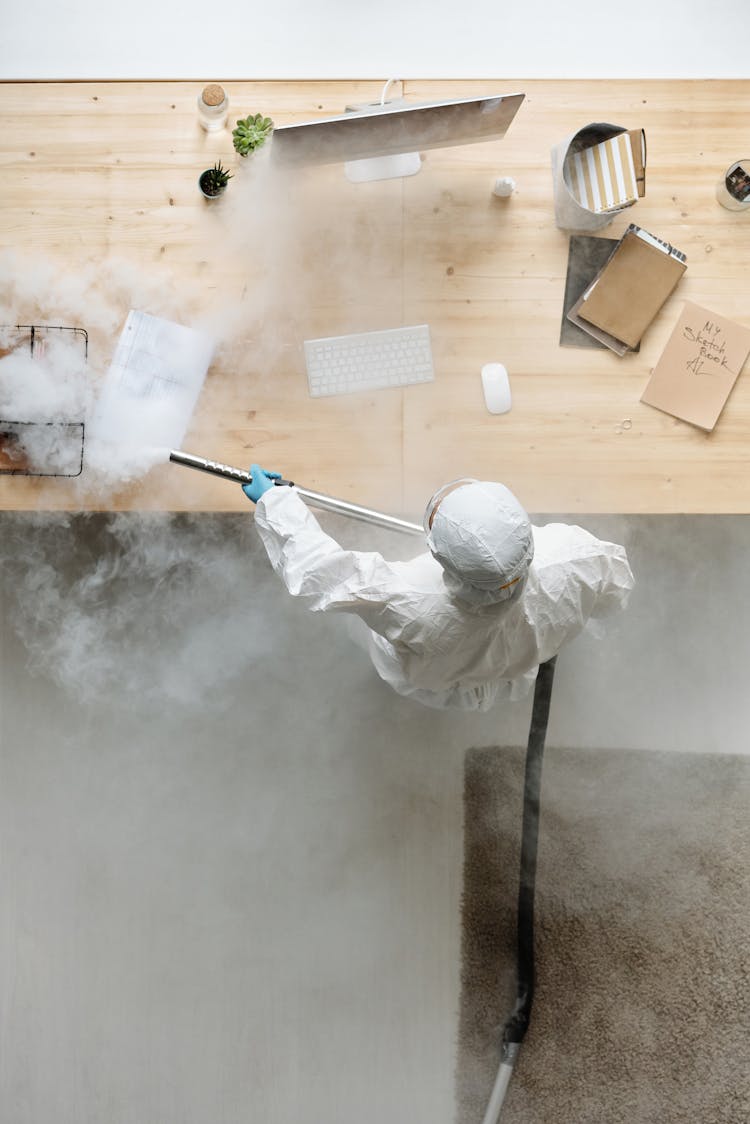 A Person Disinfecting A Table 