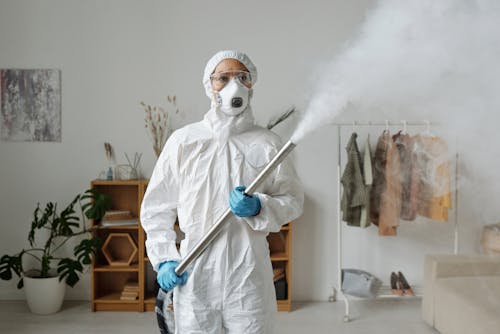 Free A Woman Fumigating While Wearing a Personal Protective Equipment  Stock Photo