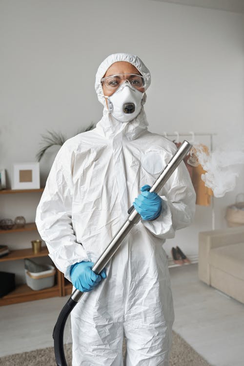 Free A Woman in a Protective Suit Holding a Disinfector  Stock Photo