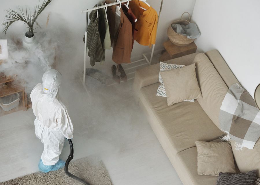 Technician in protective gear treating a home