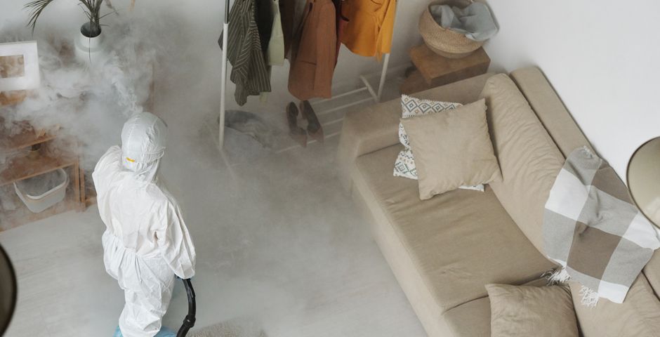 A pest control professional treating a living space — when a follow-up visit is genuinely needed