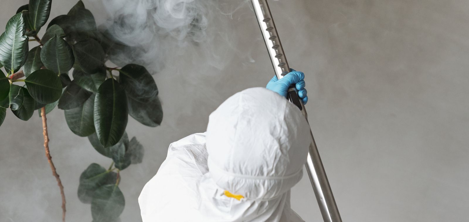 Worker in protective gear spraying indoors