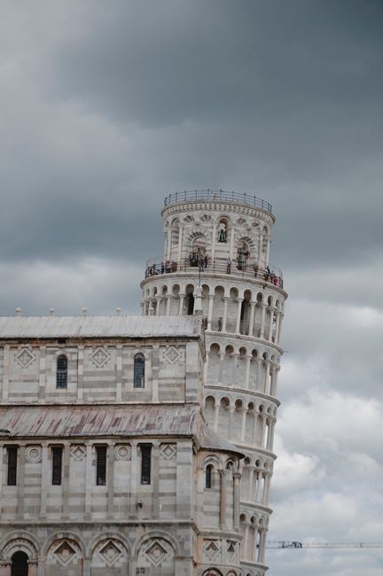 The iconic Leaning Tower of Pisa against a dramatic sky in Italy, showcasing Renaissance architecture.