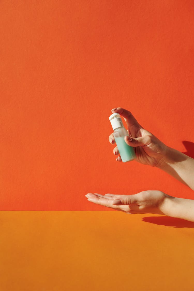 Hands Of A Person Holding A Clear Plastic Bottle