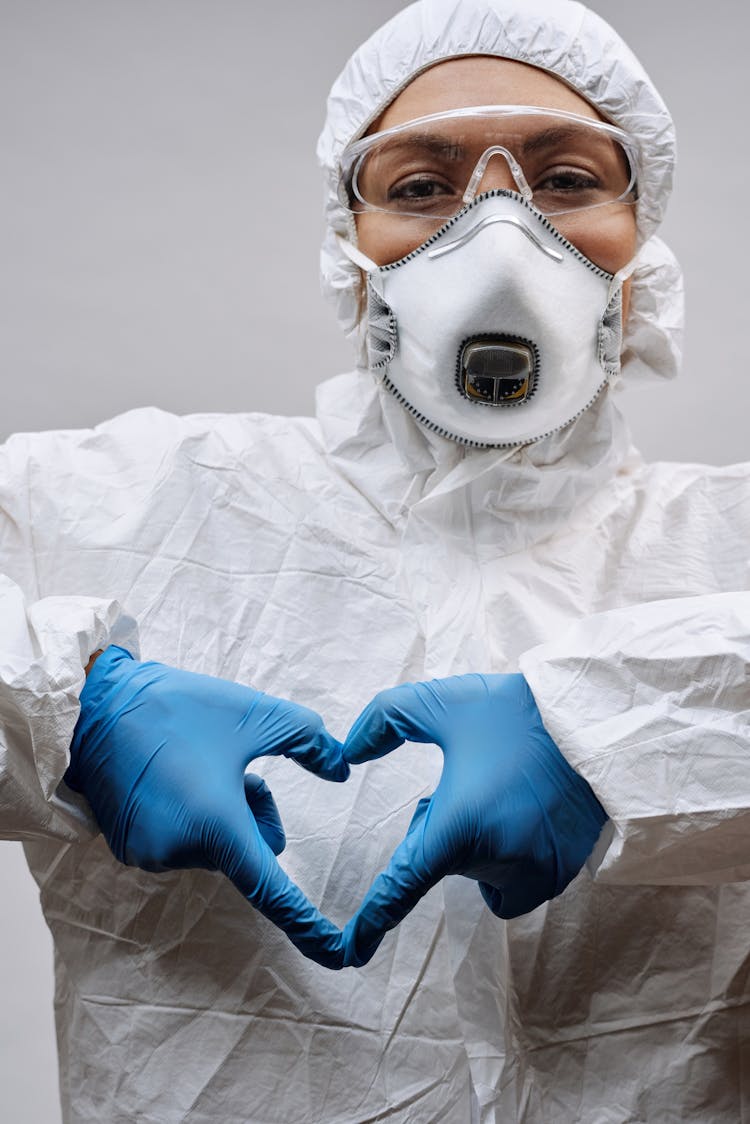 Person In White Protective Clothing Wearing Blue Gloves