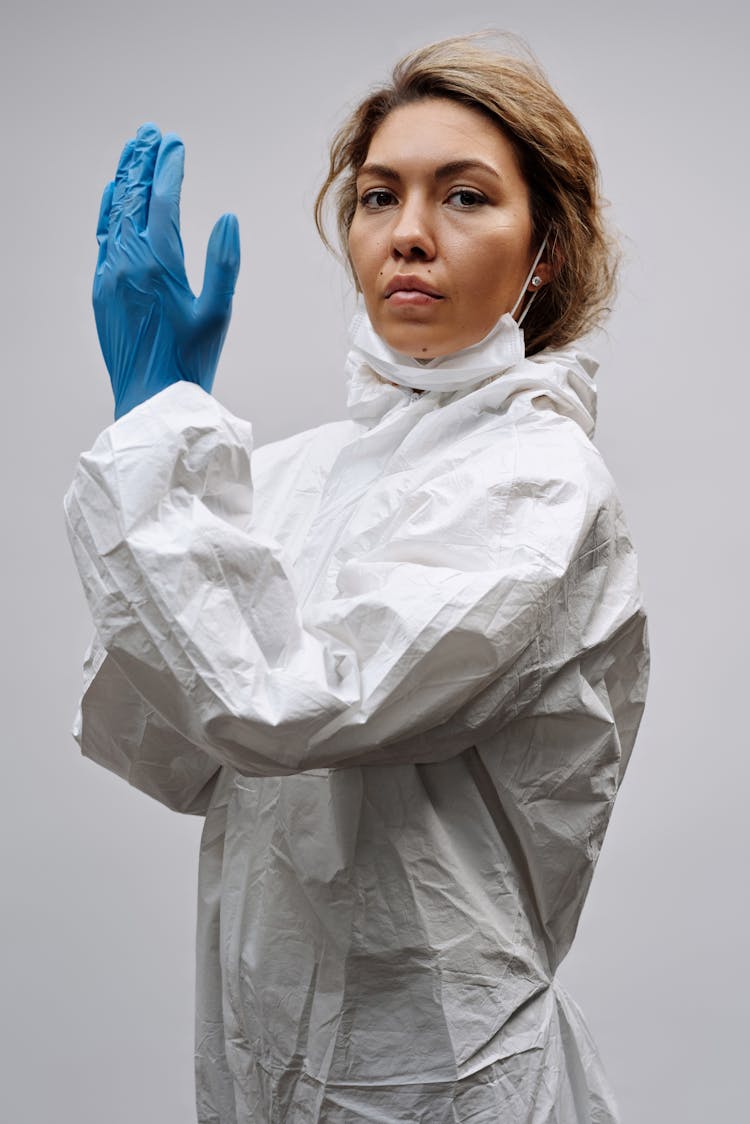 Beautiful Woman Wearing White Coveralls And Blue Latex Gloves