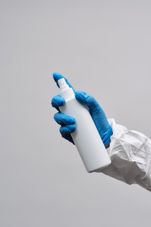 Free Hands of a Person in Gloves Holding White Plastic Bottle Stock Photo