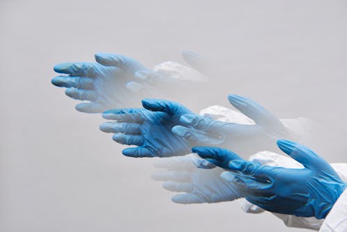 Hands of a Person Wearing Blue Latex Gloves