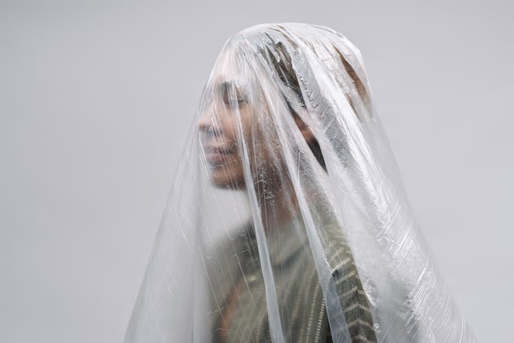 Woman Smiling Under A Clear Sheet Of Plastic