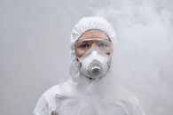 穿着防护服、口罩和护目镜的人在烟雾中的特写