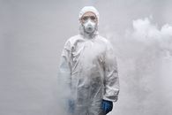 穿着防护装备的人站在烟雾中，专注于安全和预防措施