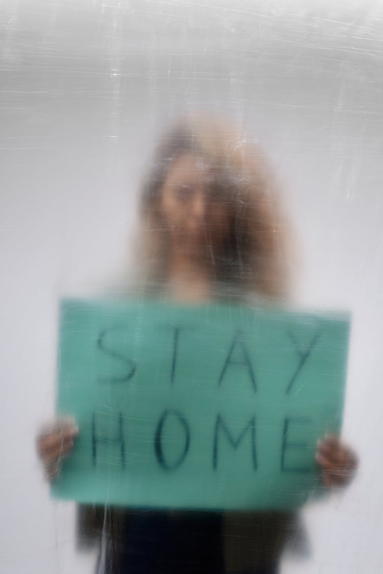 Woman Holding Green Signage Behind A Clear Plastic Sheet