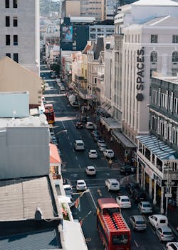 白天，市中心的建筑物和房屋之间挤满了行驶的汽车