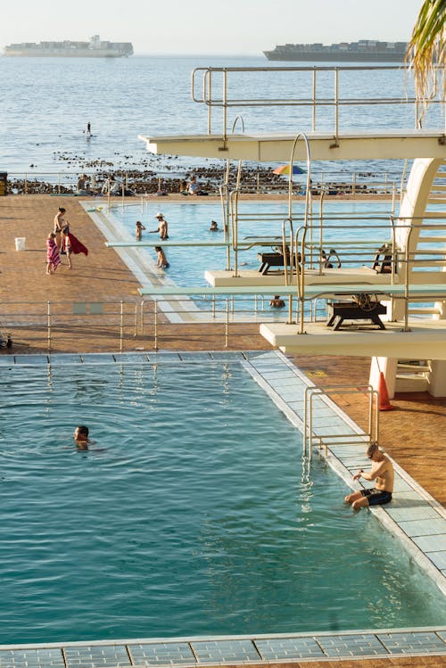 Free People swimming in pool near sea Stock Photo