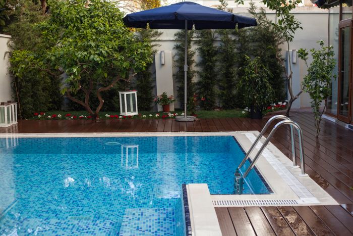 Backyard pool with wooden deck and garden