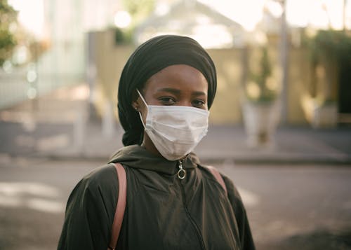 African American woman in face mask on city street