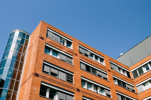 From below of contemporary high apartment building located in residential district against blue sky