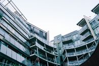 低角度视角下的现代玻璃建筑，带有阳台和挪威国旗