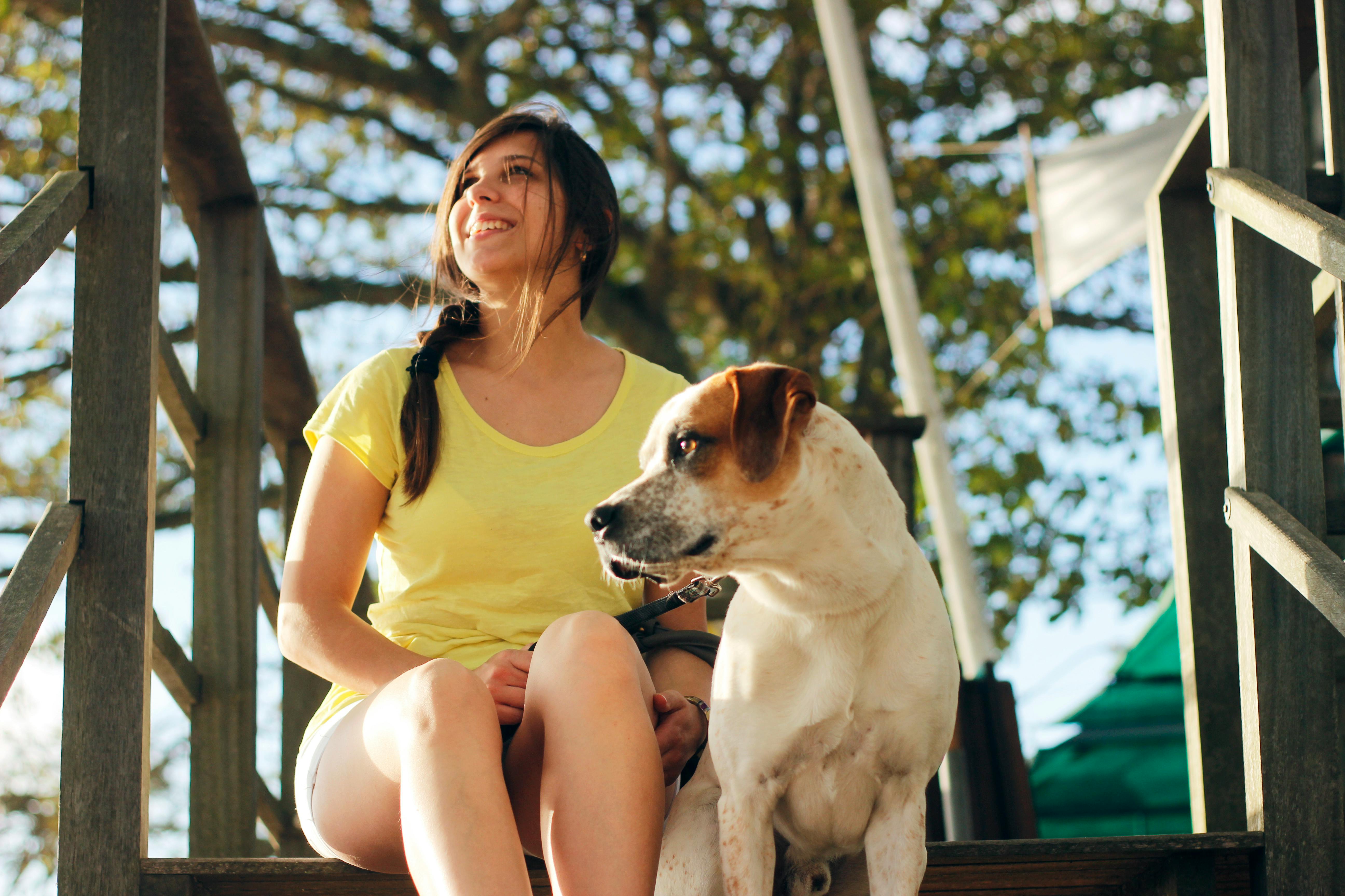 A woman and her dog sitting outside.