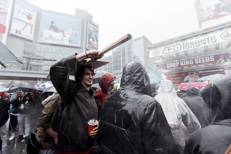 Happy Man Under Rain In Crowd