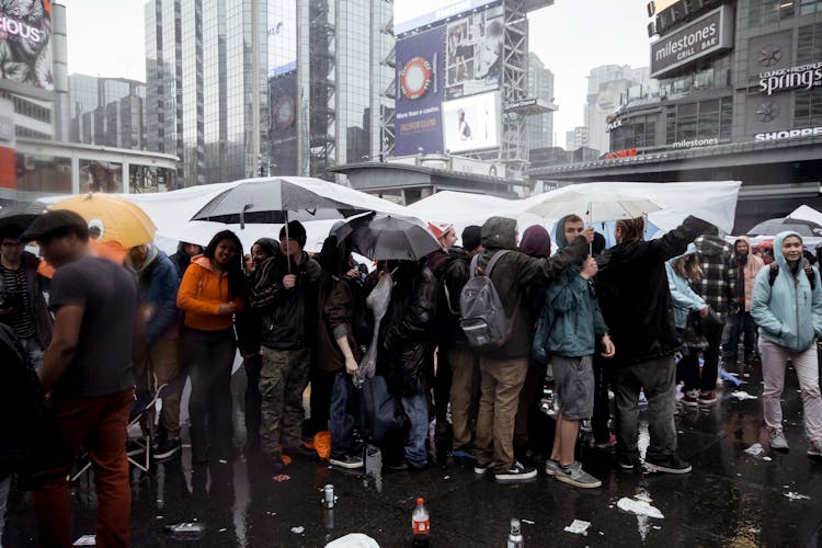 Crowd Of People Standing Under Umbrellas