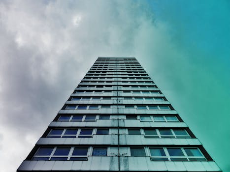 低角度视角下的现代高层建筑，背景是多云的天空
