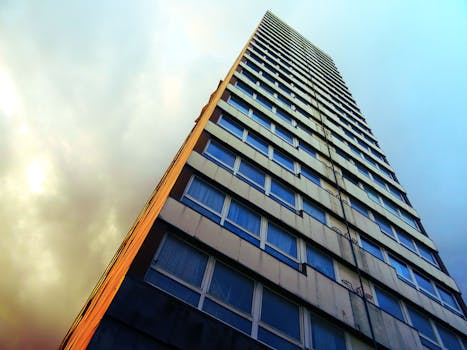 低角度视角下的现代摩天大楼，以戏剧性的天空为背景，展现了城市建筑的魅力