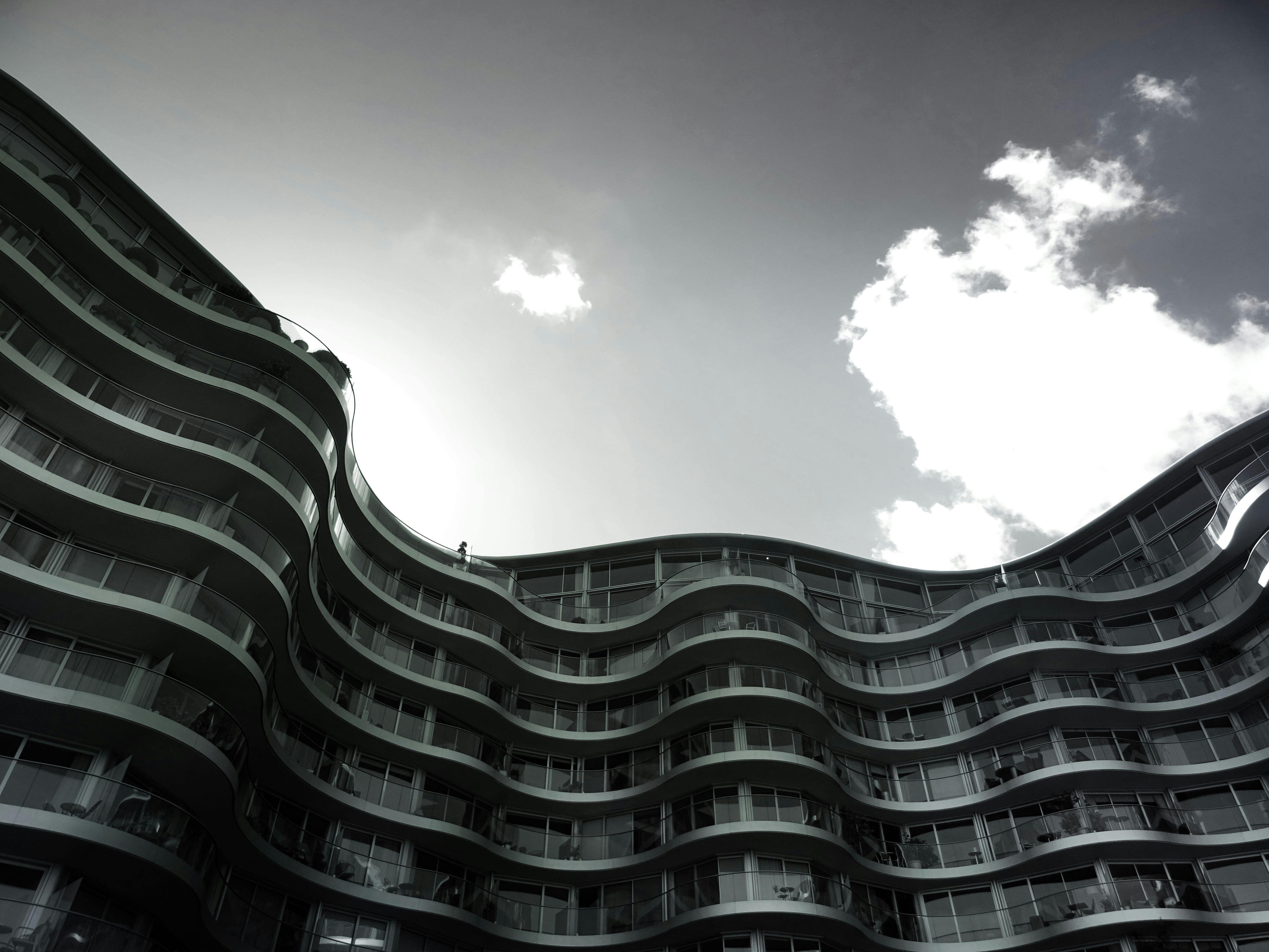 波浪形立面映衬着部分多云的天空，这座现代公寓楼引人注目