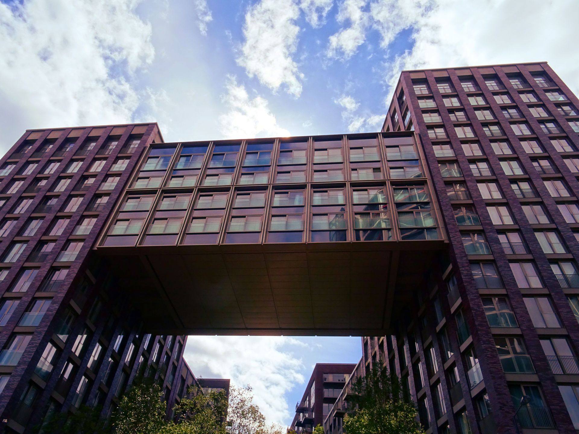 Low angle view of modern connected buildings against a blue sky.