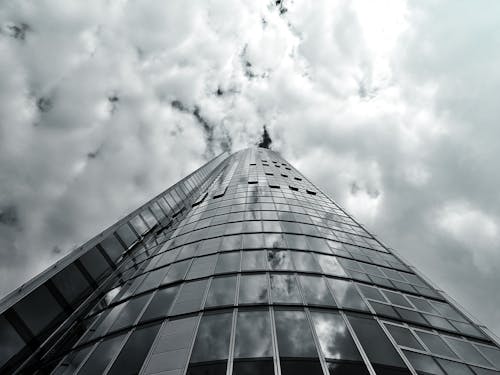 白い雲の下の灰色の高層ビル