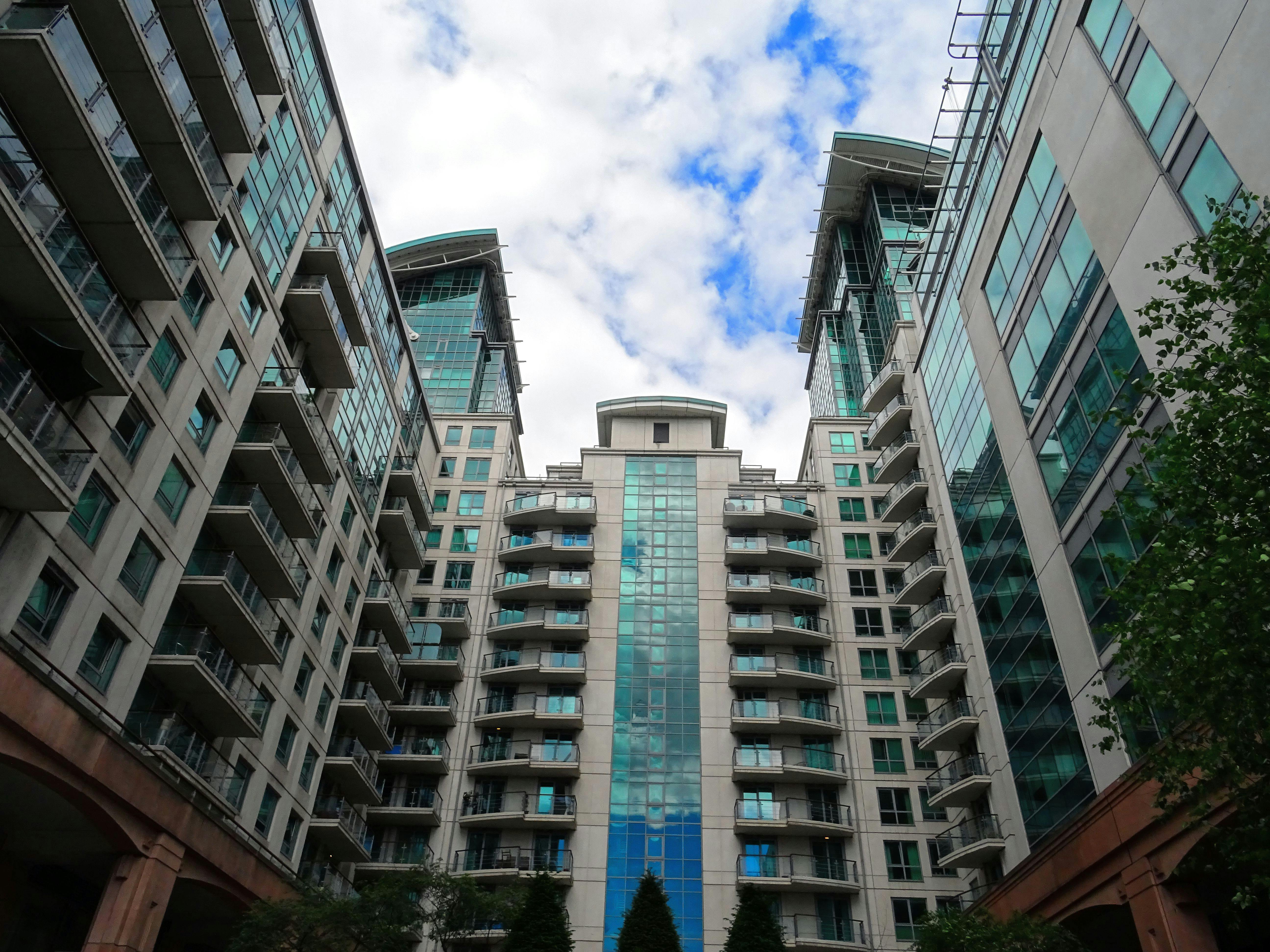 低角度仰视以蓝天为背景的现代玻璃摩天大楼，突出建筑设计