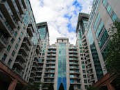 低角度仰视以蓝天为背景的现代玻璃摩天大楼，突出建筑设计