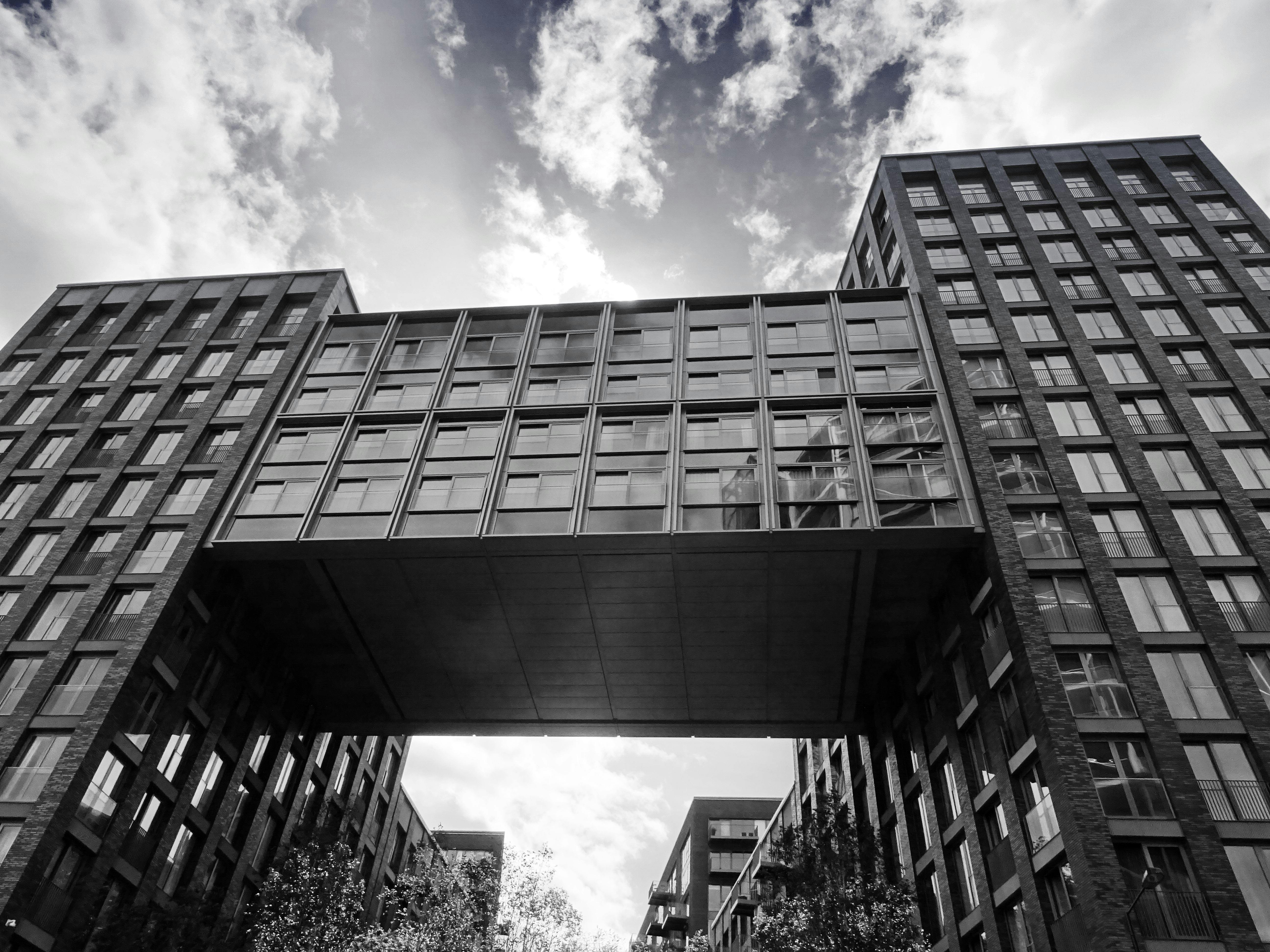 现代建筑以连接两座城市建筑的桥梁为特色，天空多云