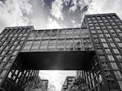 现代建筑以连接两座城市建筑的桥梁为特色，天空多云