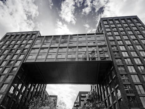 现代建筑以连接两座城市建筑的桥梁为特色，天空多云