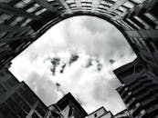 低角度镜头下的现代建筑，在戏剧性的多云天空映衬下轮廓分明