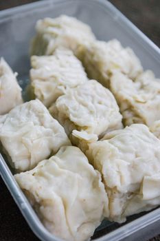 Close-up of traditional Indonesian siomay, steamed dumplings served in a container.