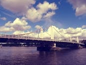 一座现代化的吊桥横跨宽阔的河流，高悬在巨大的云层之下