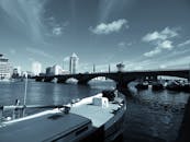 城市全景中，蓝天下可见桥梁、船只与海滨建筑