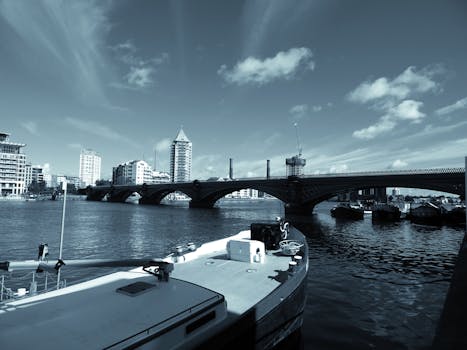 城市全景中，蓝天下可见桥梁、船只与海滨建筑