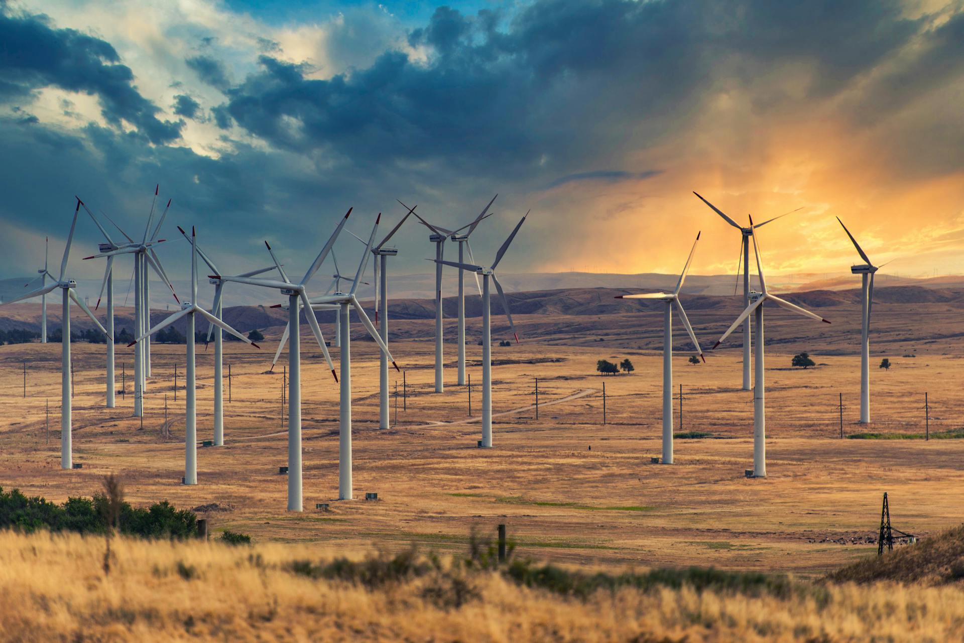 Stunning view of wind turbines on a vast plain in Kazakhstan during a dramatic sunset.