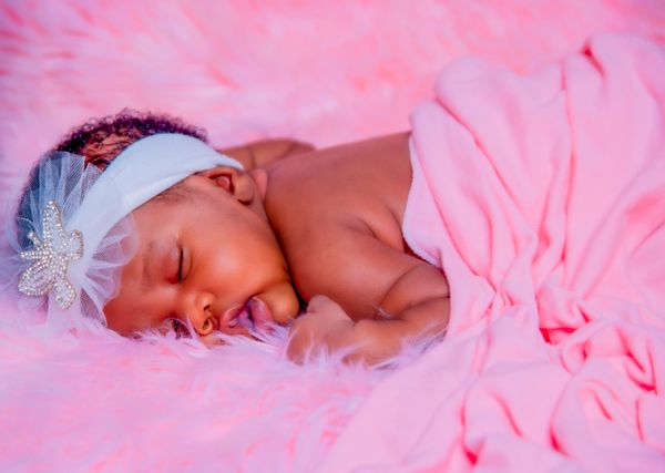 Newborn baby girl sleeping peacefully in pink