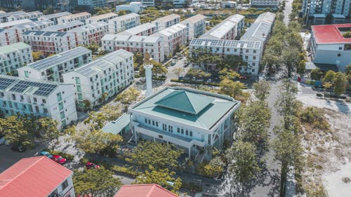 From above of modern housing complex facades near growing trees and roads in summer