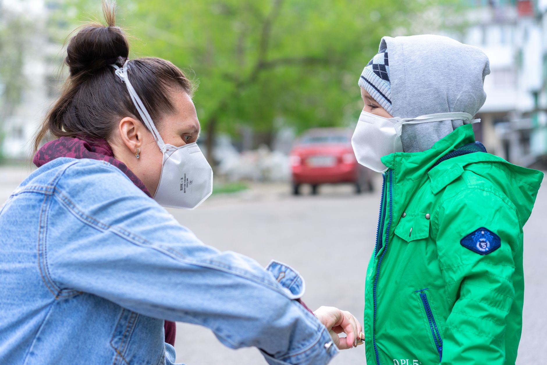 Una donna e un bambino che indossano mascherine per proteggersi all'aperto.