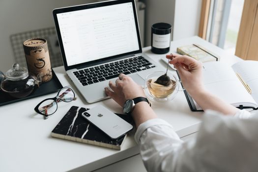 A cozy home office scene with a laptop, tea, and workspace essentials.