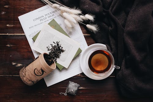 Tea, Book and Newspaper on Wooden Table