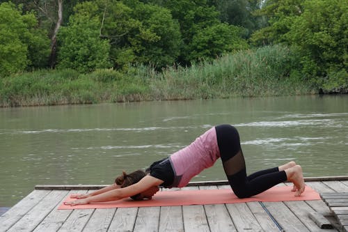Woman doing Yoga Exercises on a Pink Yoga Mat 