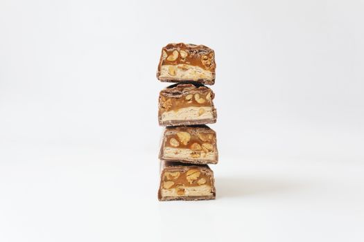 Tower of chocolate bars filled with caramel and nuts, perfect snack or indulgence treat.