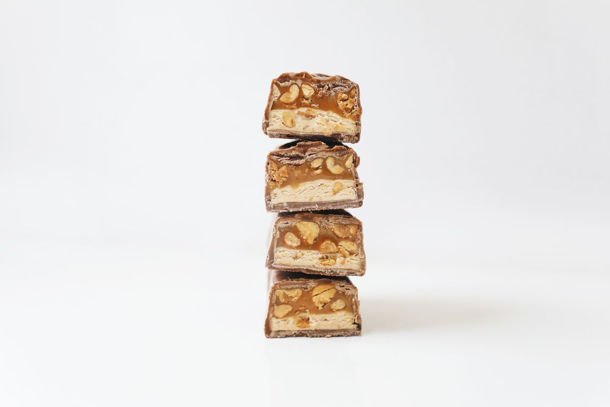 Tower of chocolate bars filled with caramel and nuts, perfect snack or indulgence treat.