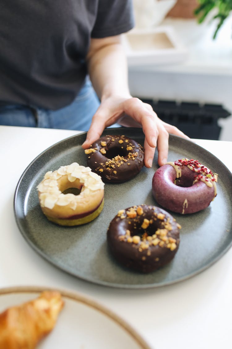 Man Reaching For Doughnuts On Tray